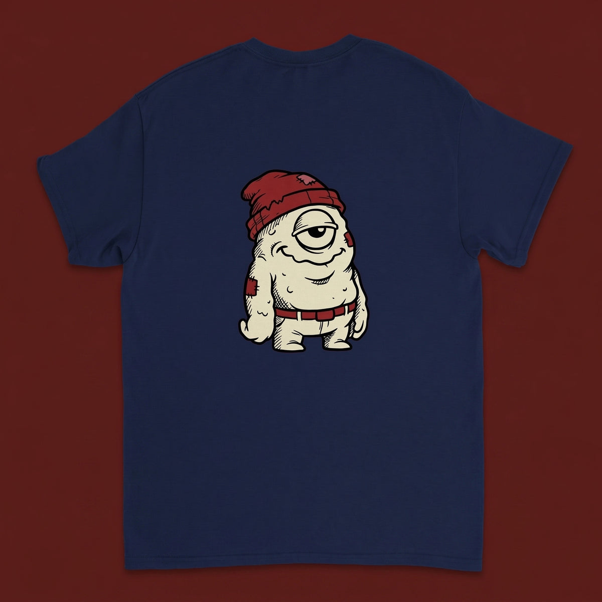 One Eye — Taylored Merch streetwear tee, oxblood studio flat-lay, navy back print