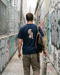Sea Legs — Taylored Merch streetwear tee, navy, worn back view street scene